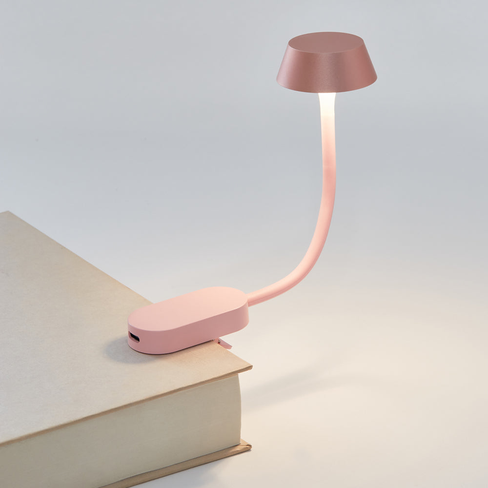 Pink clip-on book light illuminating pages