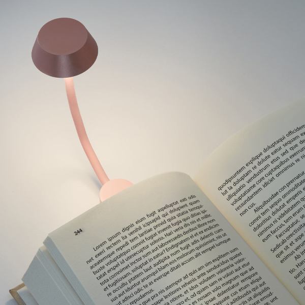 lexon mimi flexible led lamp pink Reading lamp illuminating a book page.