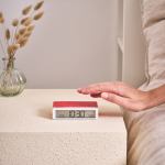 lexon flip classic reversible alarm clock pantone 2035 red Hand reaching for digital alarm clock at 10:30.