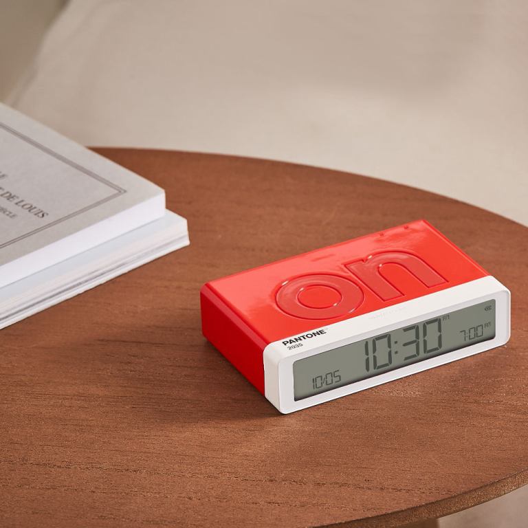 lexon flip classic reversible alarm clock pantone 2035 red Red digital alarm clock on wooden table.