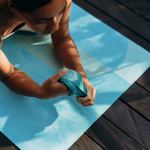 Woman practising yoga stretching on blue mat