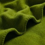 Close-up of soft, green wool fabric texture.