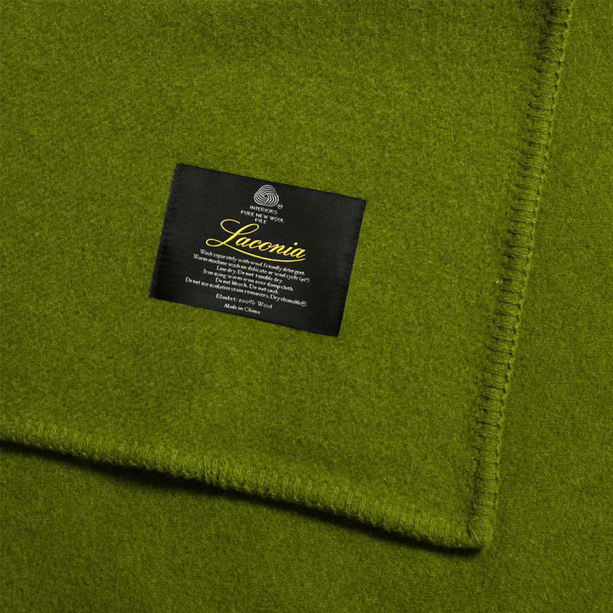 Green wool blanket with a black care label