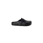 Black slip-on clog with strap, side view.