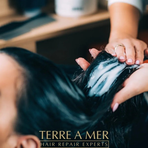Applying hair treatment at salon for repair.