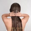 Person applying hair treatment, back view, wet hair