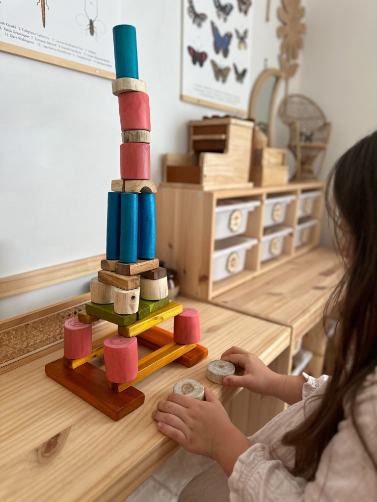 v59 469 202503201036 00.jpg Child building colourful wooden block tower.