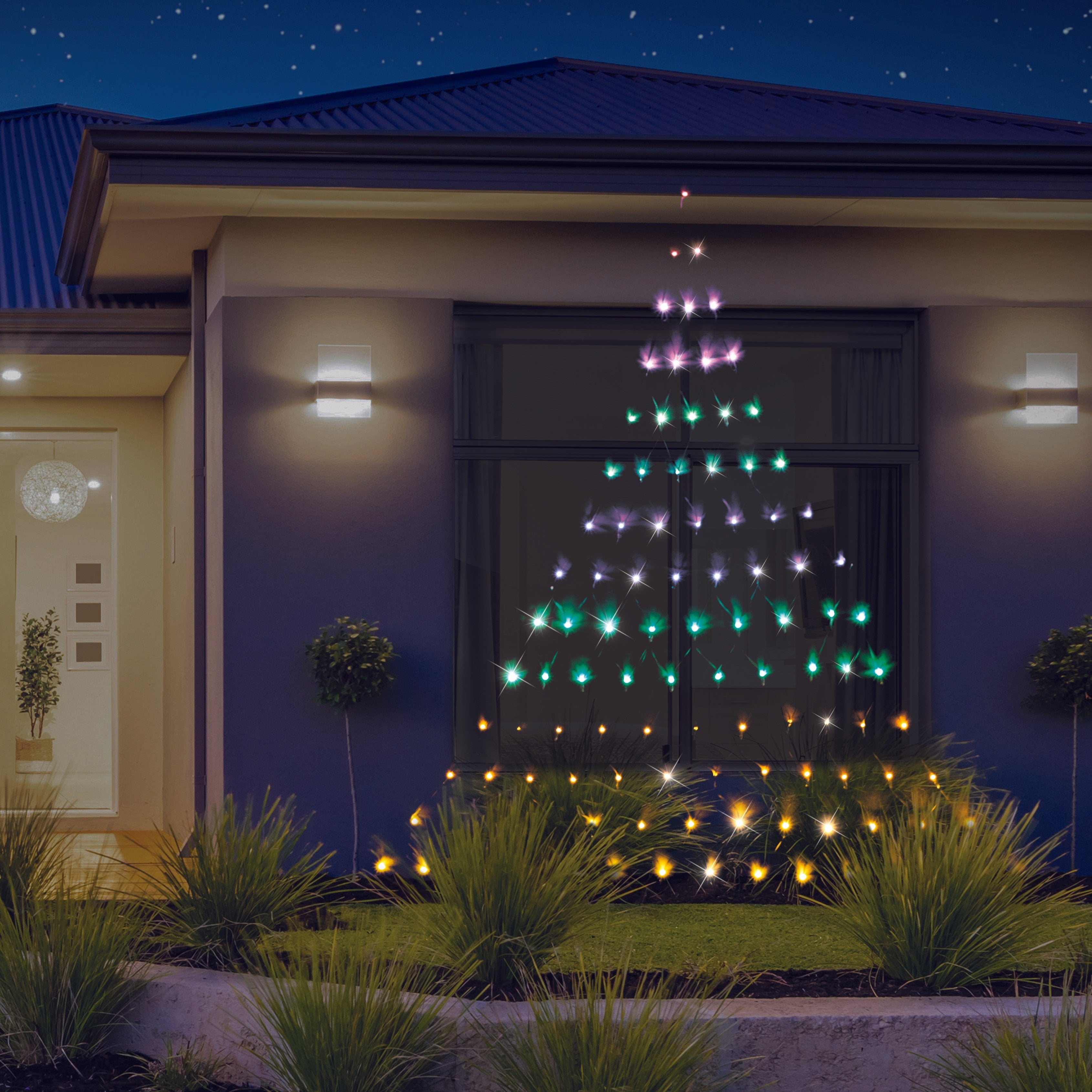 House with colourful outdoor Christmas lights at night.
