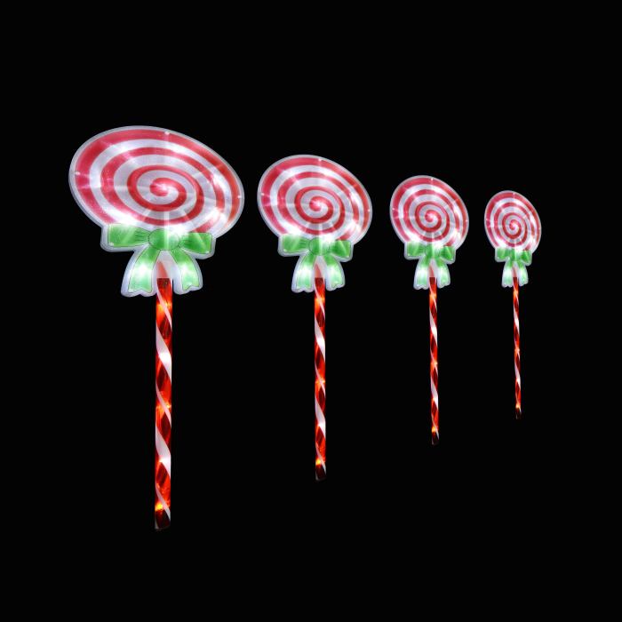 Four spiral lollipops with green bows on sticks.