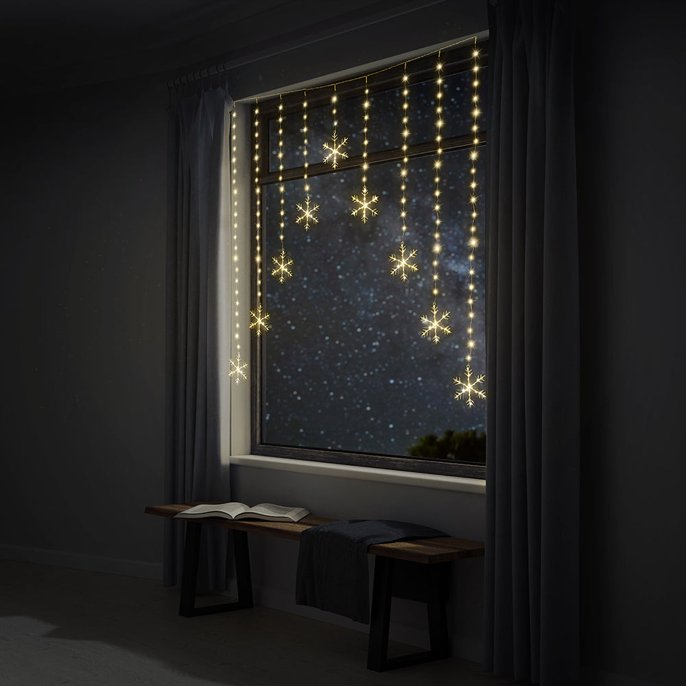 Snowflake string lights decorating a window.
