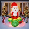 Inflatable Santa decoration with drums, snowy front yard.