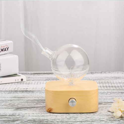 Glass aromatherapy diffuser on wooden table.