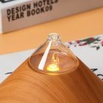 Wooden aroma diffuser with glowing light, close-up view.