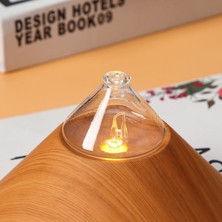Wooden aroma diffuser with glowing light, close-up view.