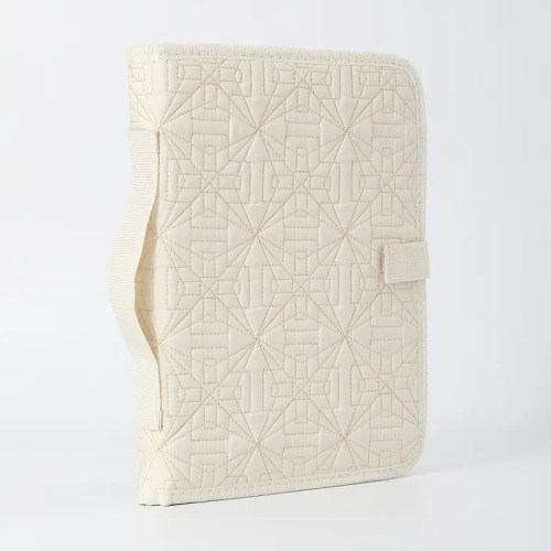 Beige quilted fabric folder with geometric patterns.