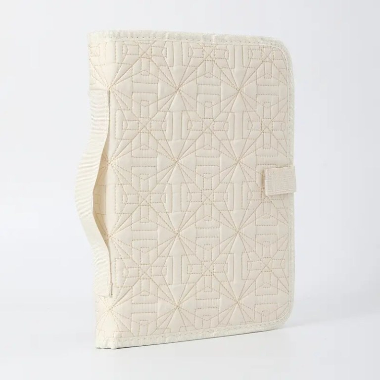 Beige quilted fabric folder with geometric patterns.