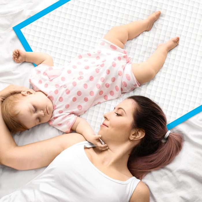 40pk adult disposable bed underpads 60 x 90cm Mother and baby lying on white bed.