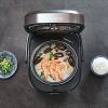 Rice cooker with seafood porridge and side dishes.