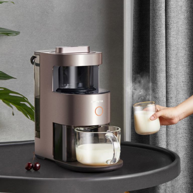 Person serving hot milk with milk frother.
