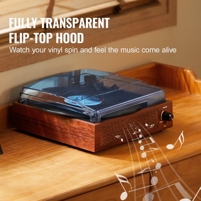 Turntable with transparent hood on wooden table.