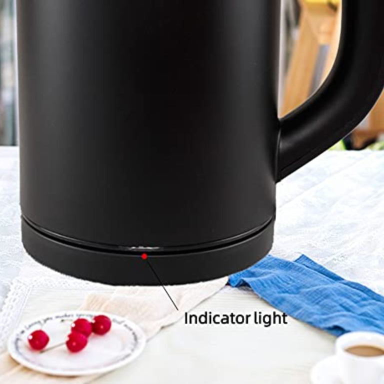 Black kettle with indicator light on table.