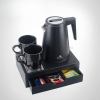 Black kettle set with cups and tea packets.