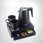 Black kettle set with cups and tea packets.