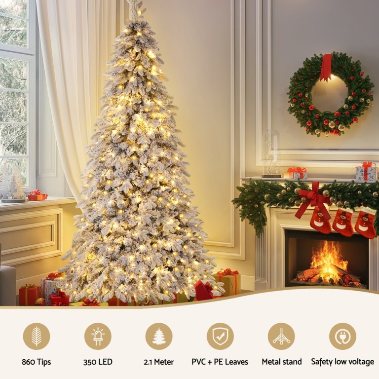 jingle jollys christmas tree 2.1m flocking pencil tree led xmas 860 tips white Decorated Christmas tree by a cosy fireplace.