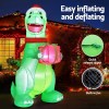 Inflatable dinosaur with gift, Christmas lights background.