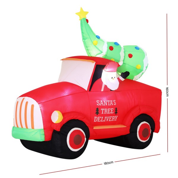 Inflatable red truck with Santa and Christmas tree.