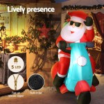 Inflatable Santa decoration with LED lights on scooter.