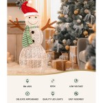 Festive LED snowman decoration beside Christmas tree.