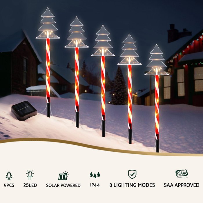 Solar Christmas tree lights in snow-covered yard.