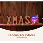Christmas decorations with colourful lights on wooden shelf.