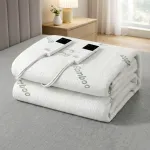 Folded bamboo electric blanket with controls on bed.