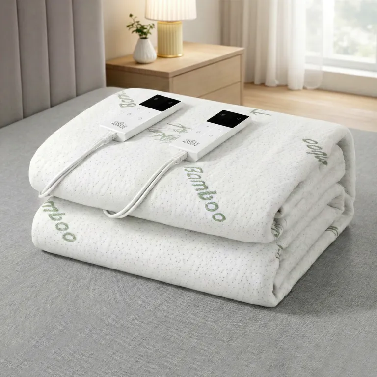 Folded bamboo electric blanket with controls on bed.