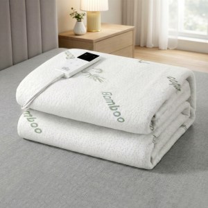 Bamboo electric blanket with remote on bed