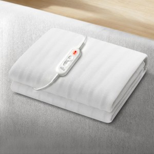 Folded electric blanket on bed with remote