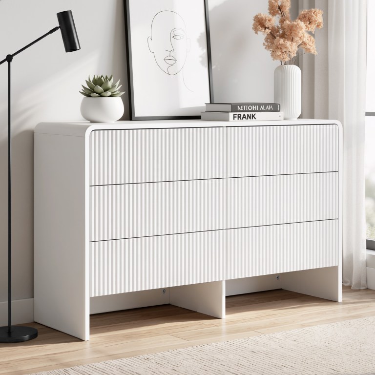 Modern white dresser with decor and wall art.