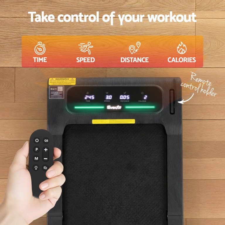 Treadmill with remote control and workout metrics display.