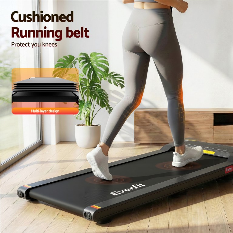 Woman jogging on cushioned treadmill indoors.