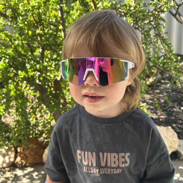 Child wearing sunglasses outside, shirt says Fun Vibes.