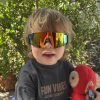 sportiq jnr kids crimson onyx Child wearing colourful sunglasses holding red toy