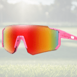 Pink sports sunglasses on grassy field.