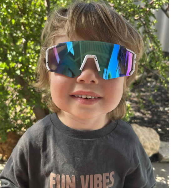 sportiq jnr kids snow blue Child wearing colourful sunglasses outdoors.