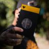 Person holding a yellow and black device outdoors.