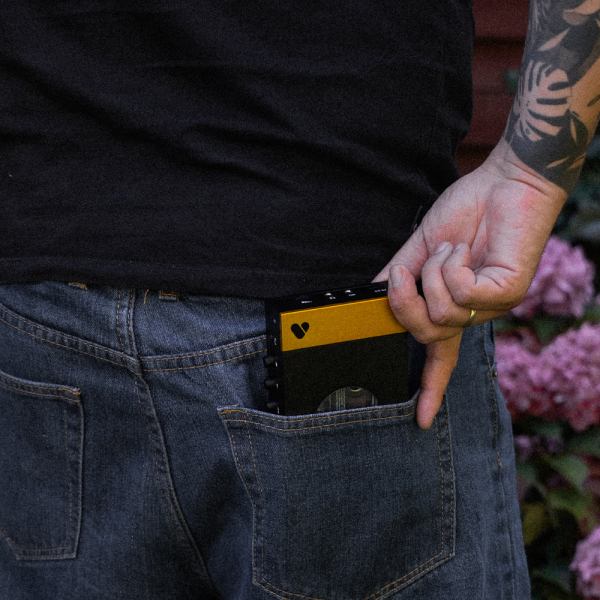 Pocketing a black and yellow cassette tape