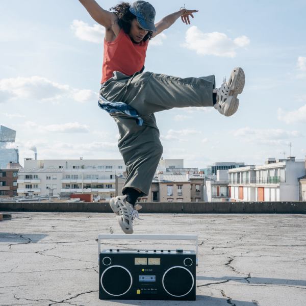 we are rewind getto blaster cassette player & recorder curtis, black Person dances energetically on rooftop with boombox.