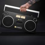 Tattooed hand holding vintage portable radio.