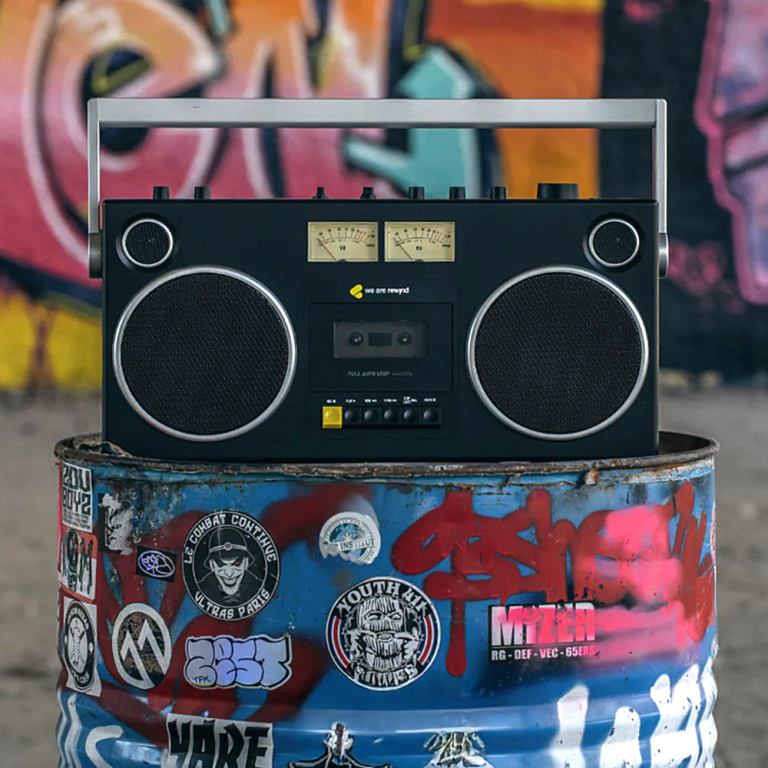 Retro boombox on graffiti-covered barrel.